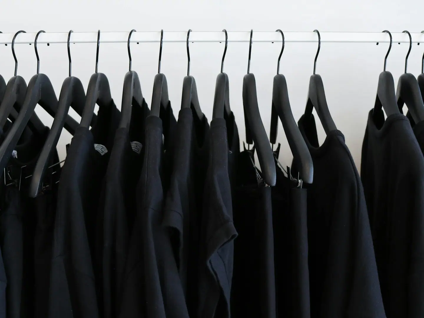 A rail of dark garments hung close together.