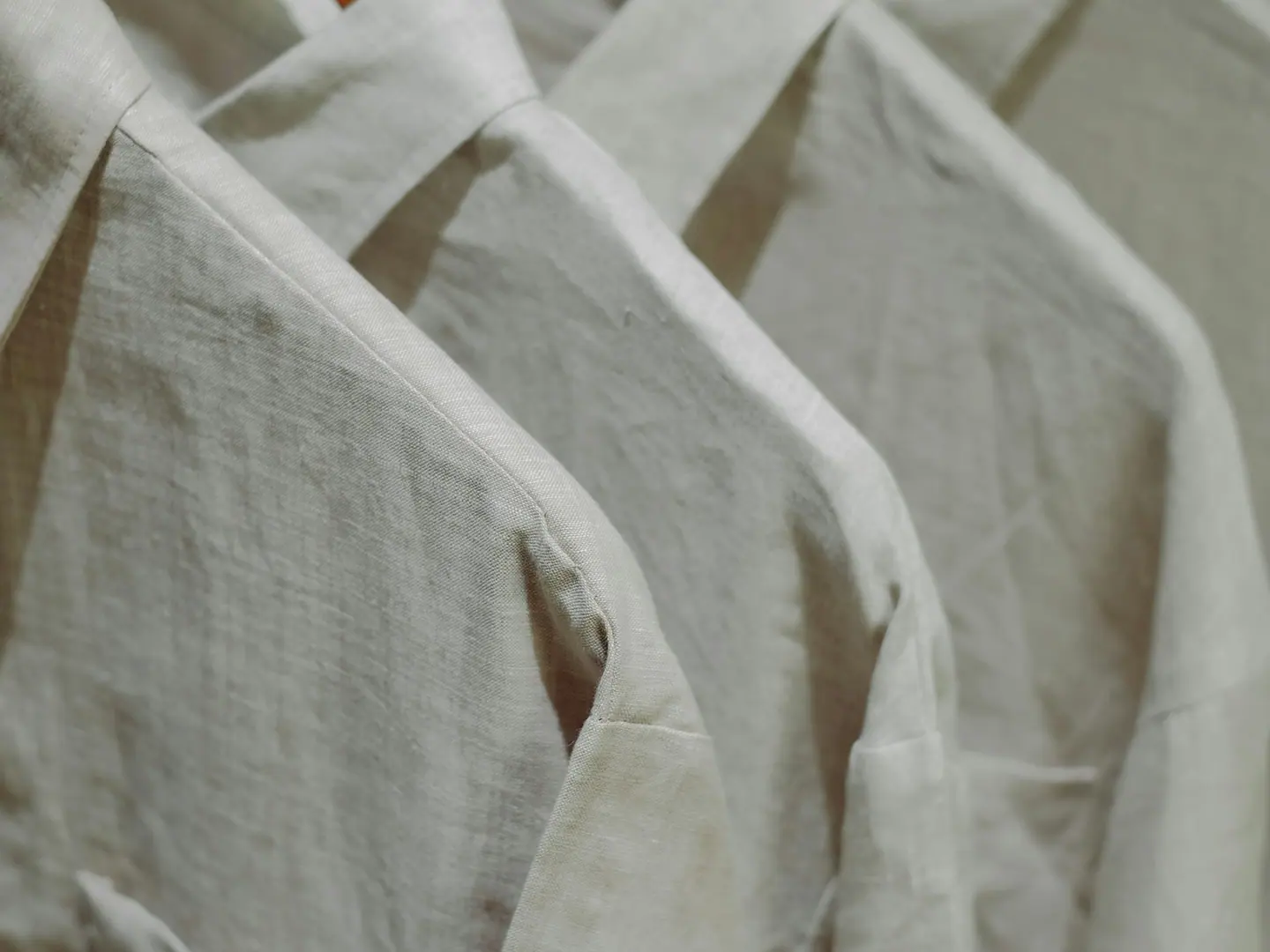 Linen shirts folded in a stack on a shelf in the shop.