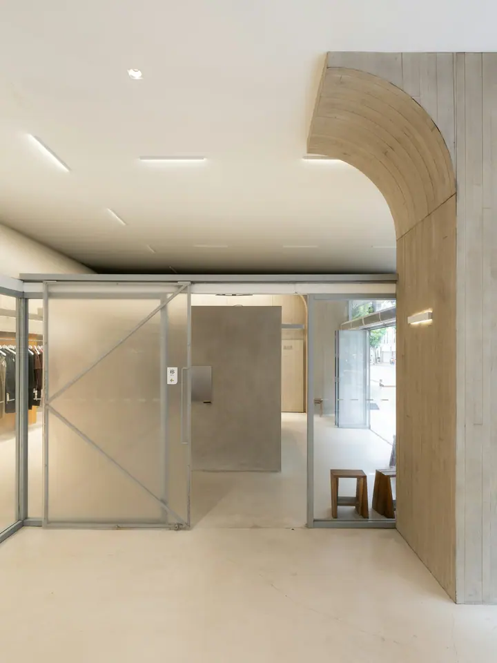 The shop interior: a concrete arch, glass partitions, daylight from the left.