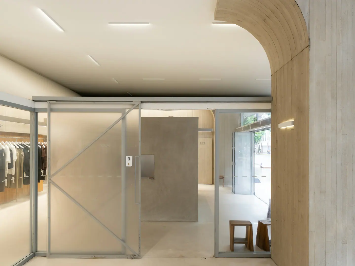 The shop interior: a concrete arch, glass partitions, daylight from the left.