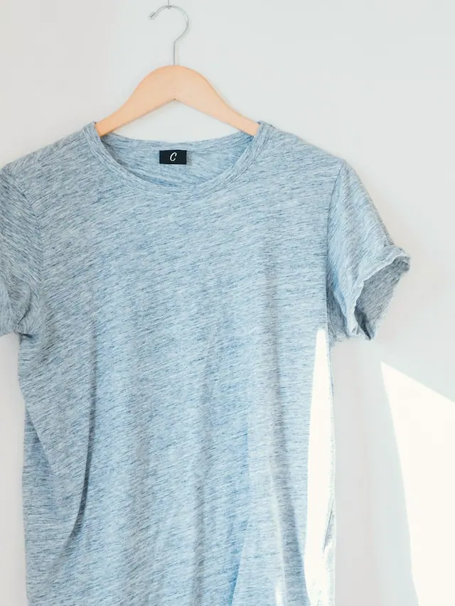 The Marl Tee in indigo marl slub cotton jersey, laid flat on grey pattern paper.