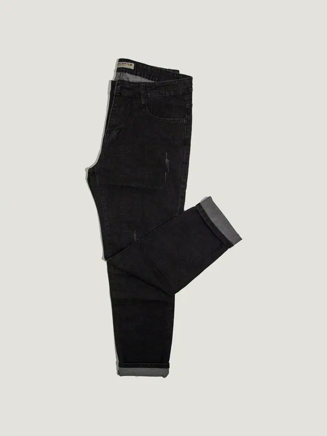 The Tapered Trouser in black cotton drill, laid flat on grey pattern paper.